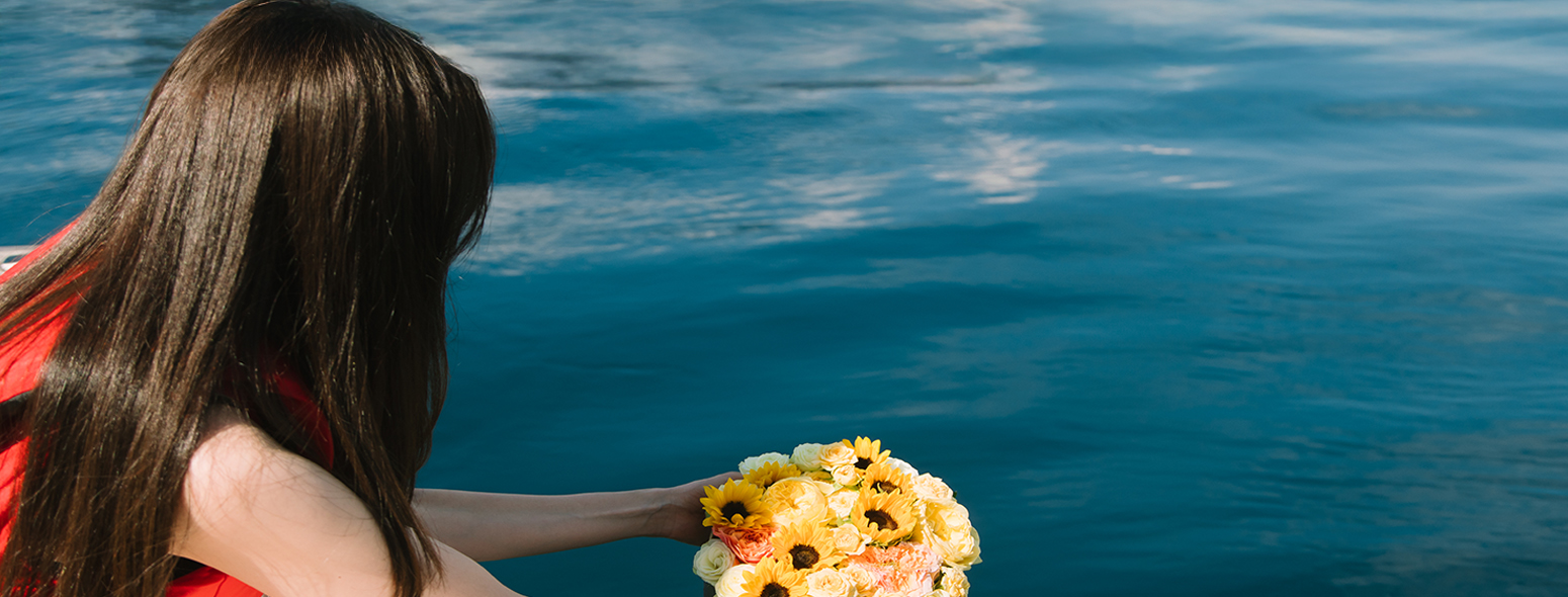 海洋散骨の様子。女性が海へ献花をしています。